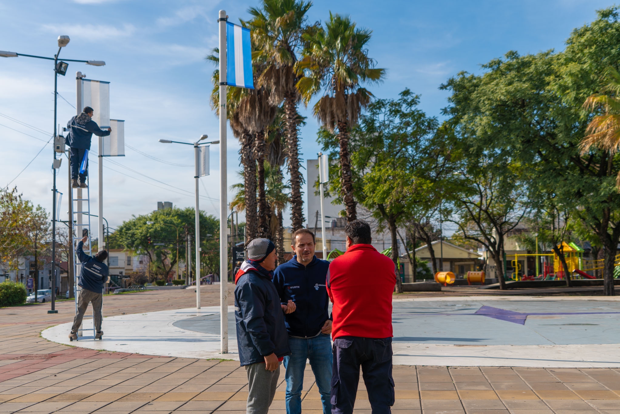 figureti mientras empleado municipal cambiando bandera vieja por nueva