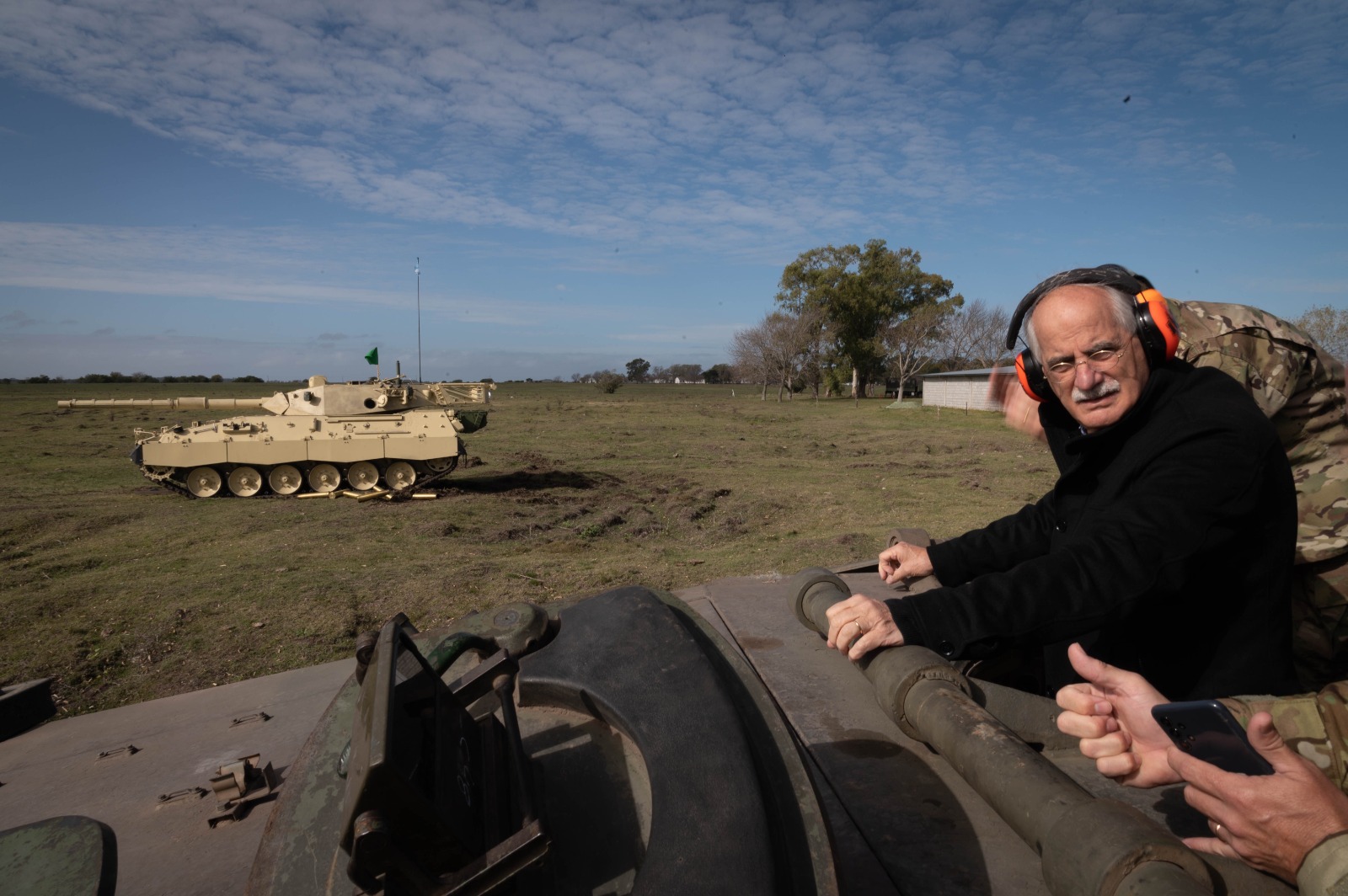 Taiana arriba de un tanque oyendo a los militares