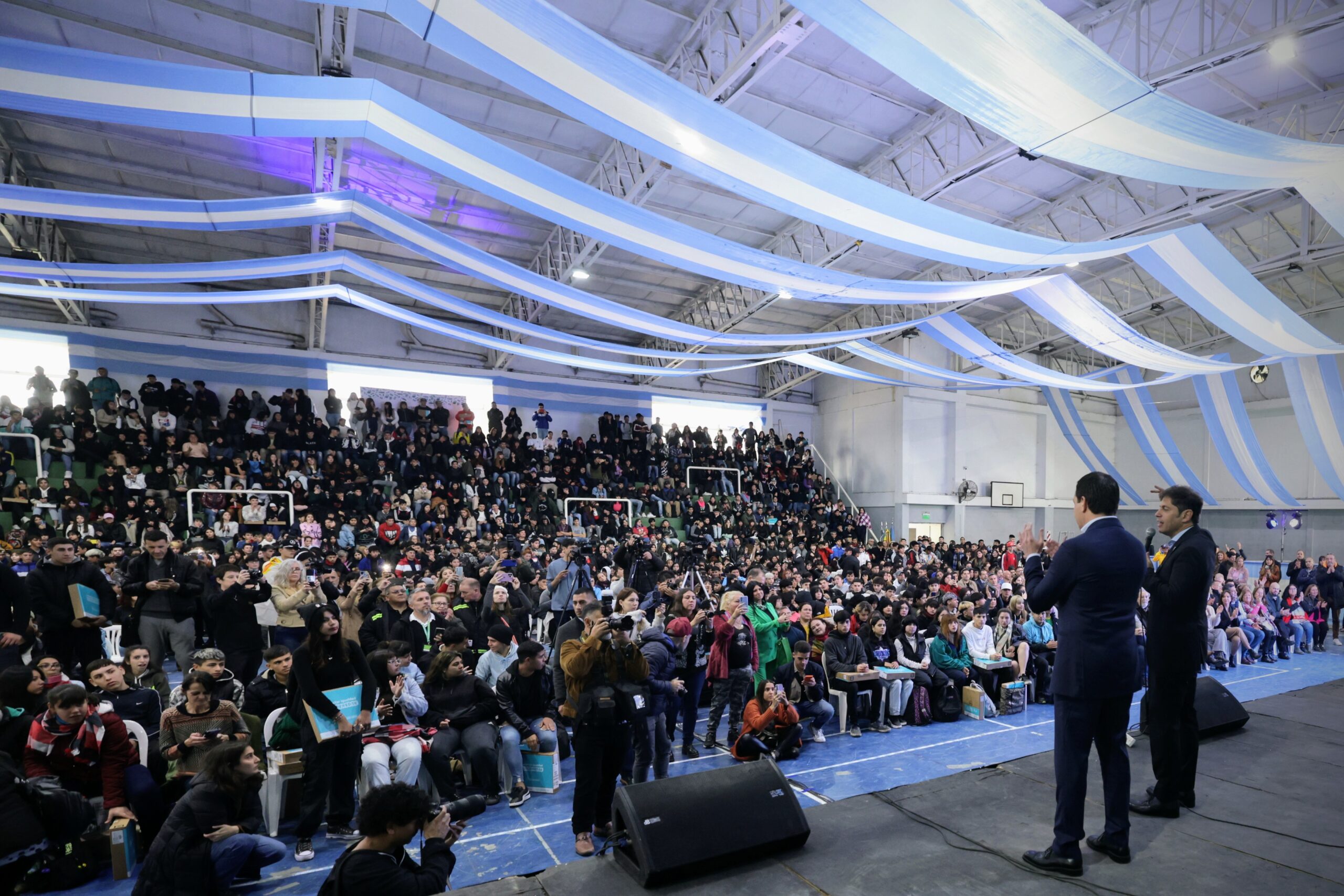 Kicillof dando discurso en el acto ante una multitud de adolescentes a la espera de recibir entrega de computadoras