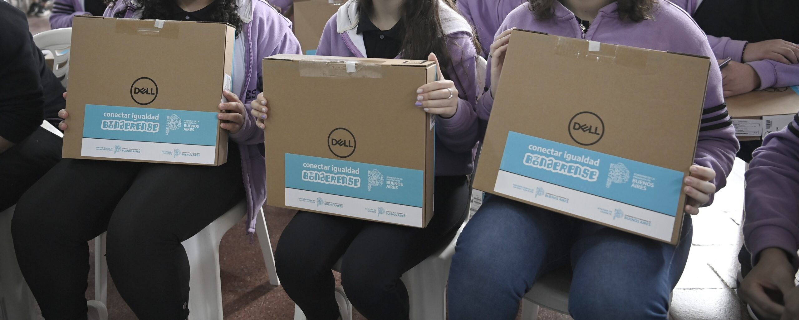Alumnos del último año enseñando las computadoras que recibieron
