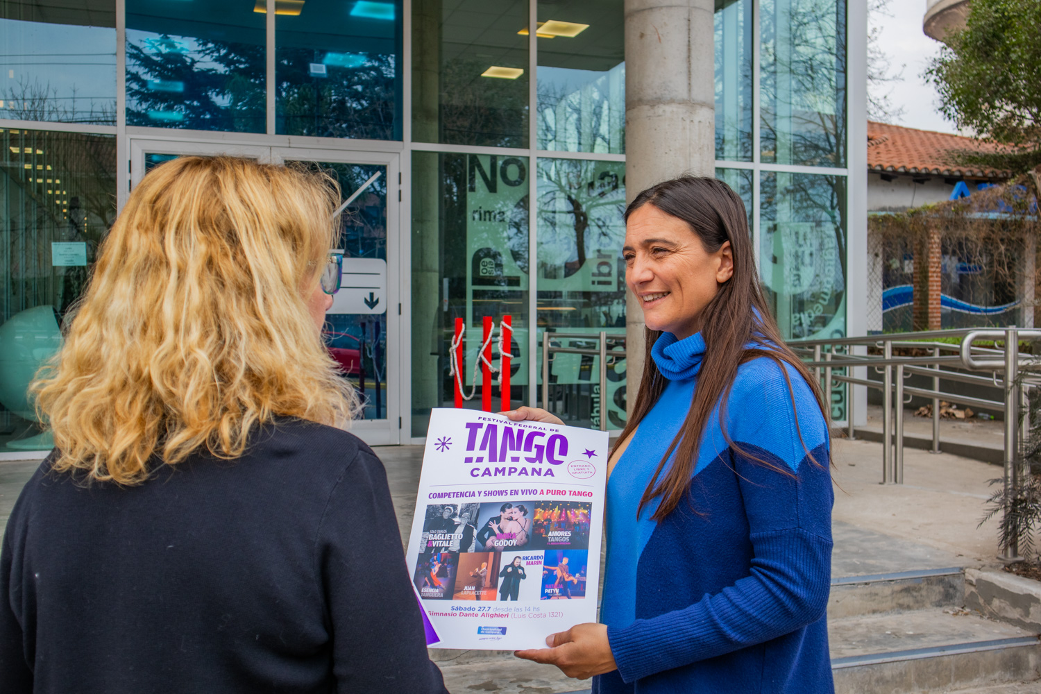 Foto de Elisa Abella sosteniendo un flyer del evento