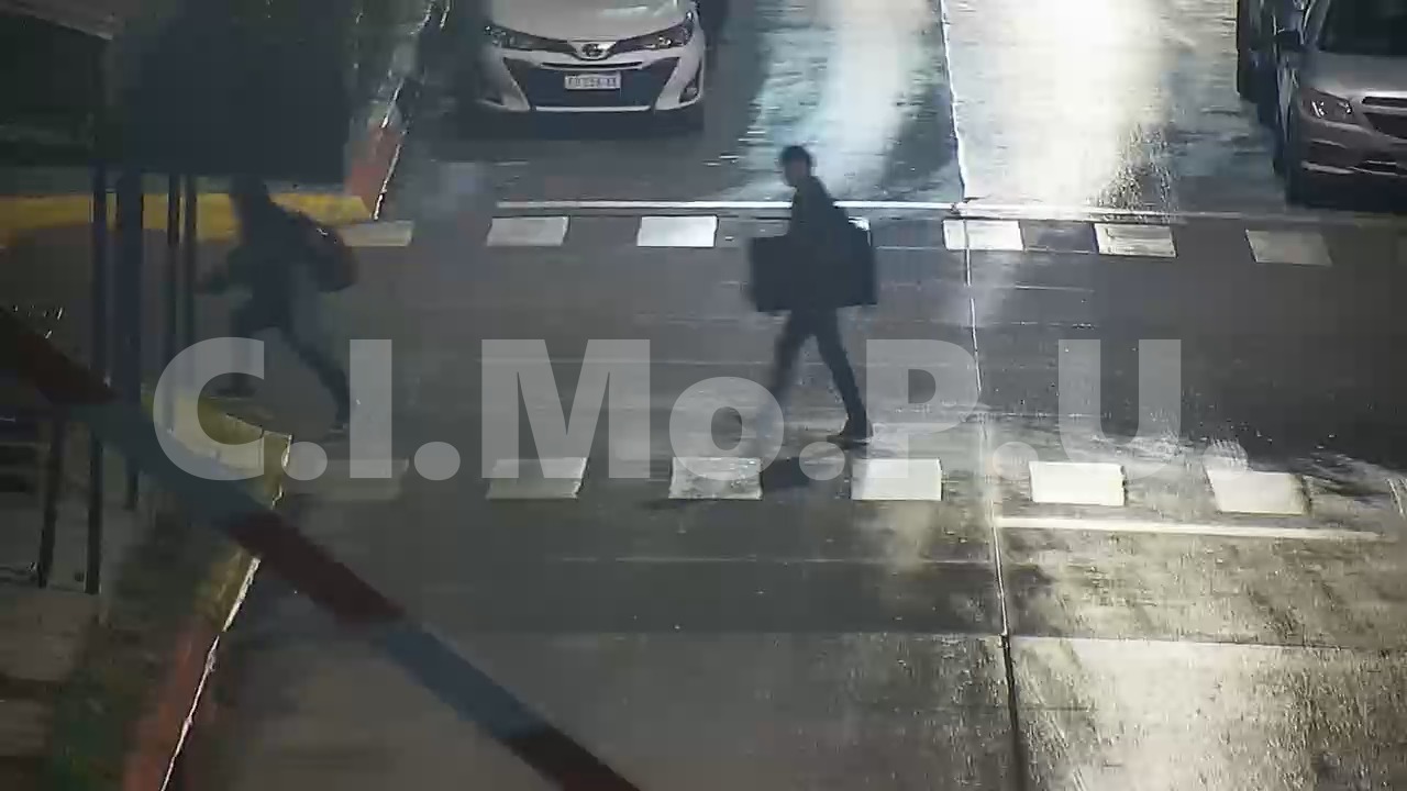 imagen tomada por cámara de seguridad donde se ve a uno de los sujetos caminando con el televisor debajo del brazo cruzando la calle